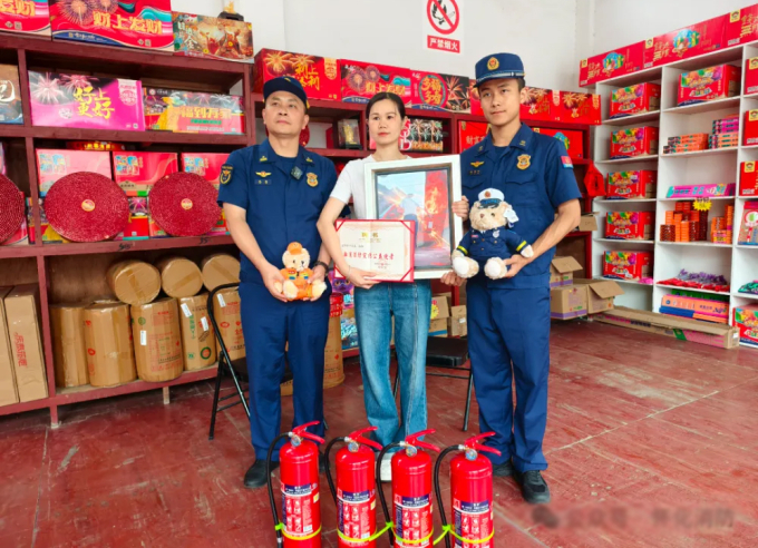 Shu Dan (giữa) nhận bằng khen và 4 bình chữa cháy từ đội cứu hỏa. Ảnh: QQ