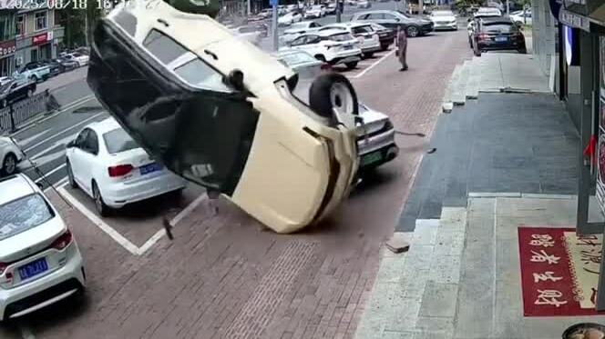 Xe SUV mất lái, lao qua dải phân cách và đổ lên xe đỗ